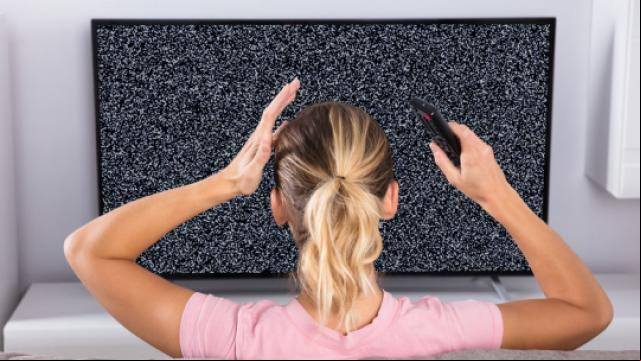 Image showing fuzzy screen with a frustrated lady holding a remote control 